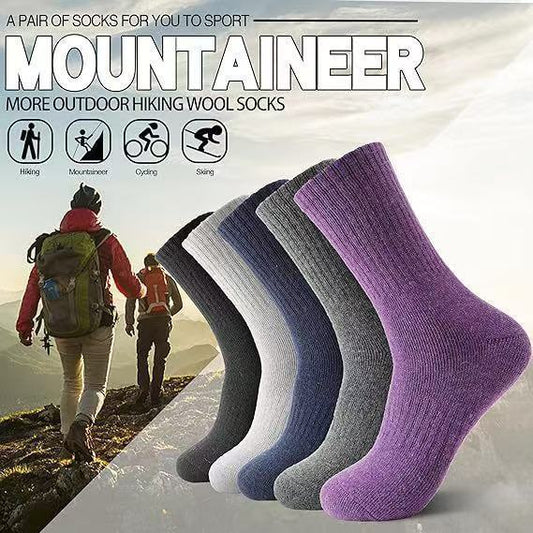 Outdoor hiking wool socks in black, gray, and purple with hikers on mountain trail in background